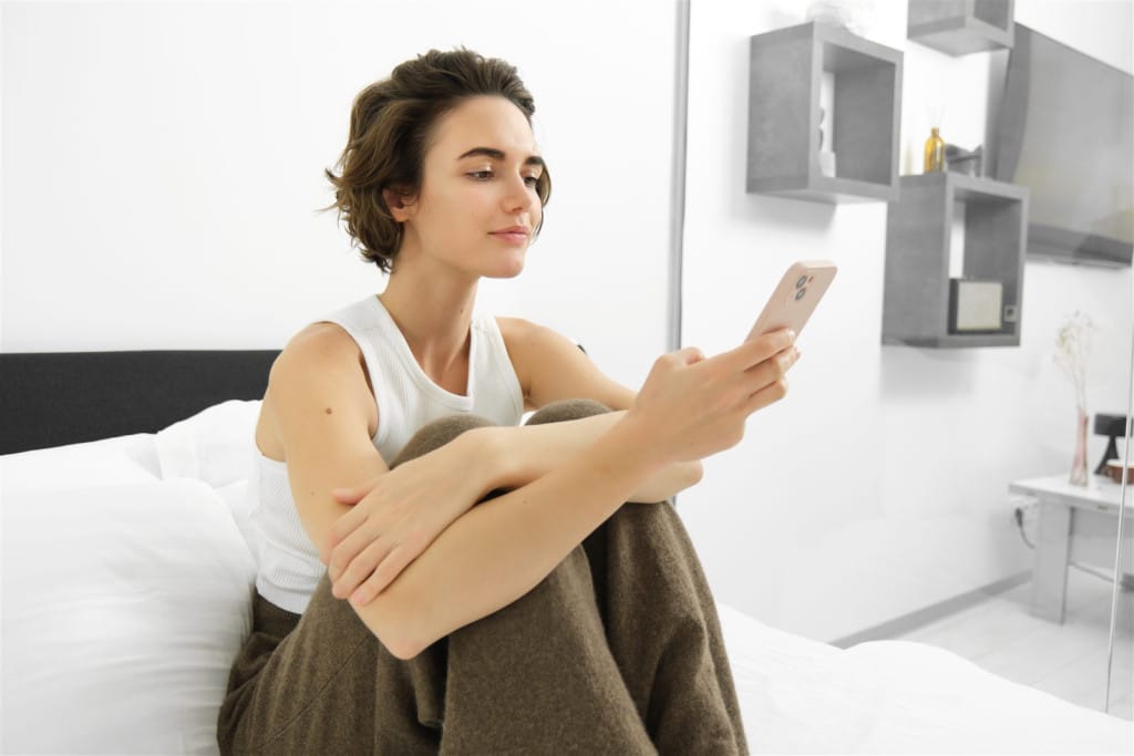 Tânără pe telefon, expusă presiunii sociale asupra imaginii corporale