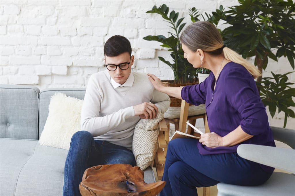 Psiholog oferind sprijin unui tânăr în terapie pentru anxietate socială